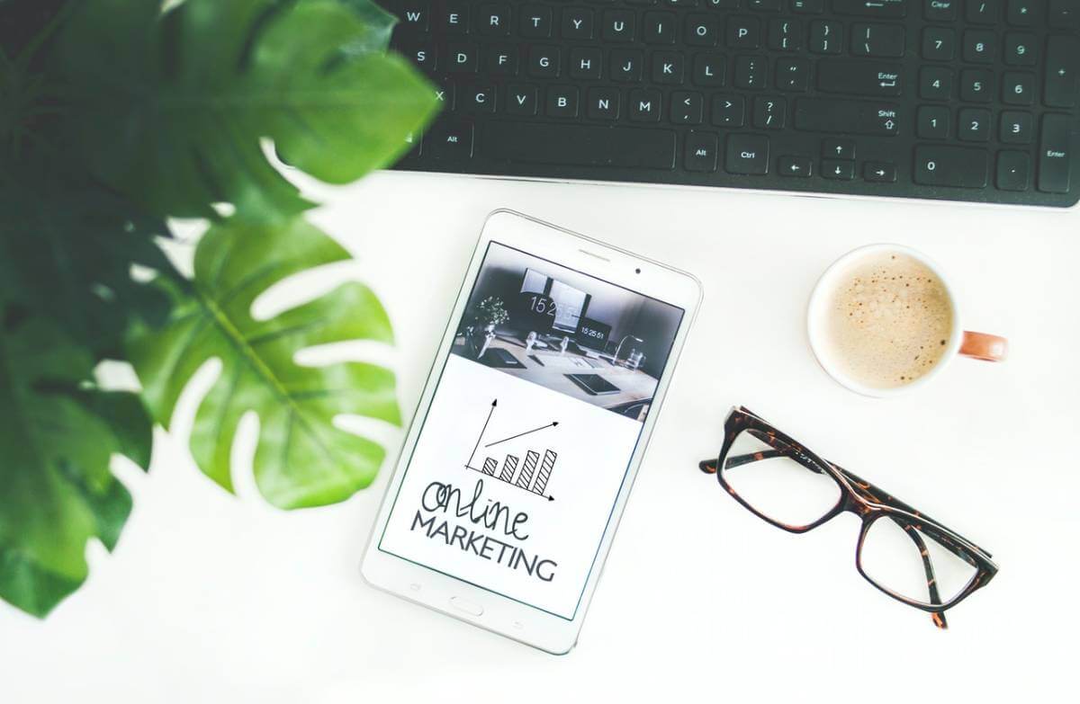  a phone, spectacles, and a cup of coffee on a table.